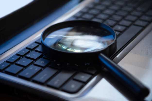 Magnifying glass sitting on top of a laptop keyboard