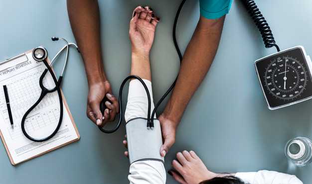 Nurse taking blood pressure of patient's arm